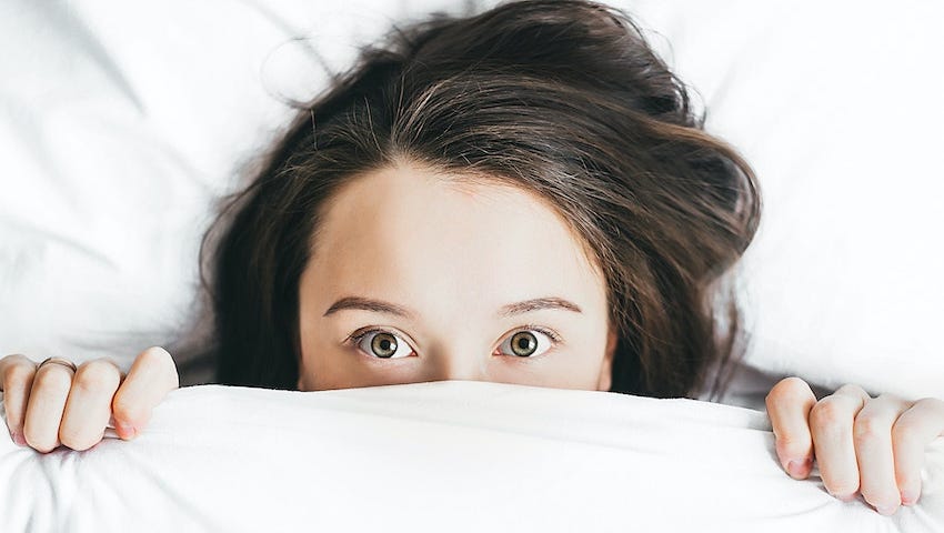 Picture of a fearful girl under her blanket