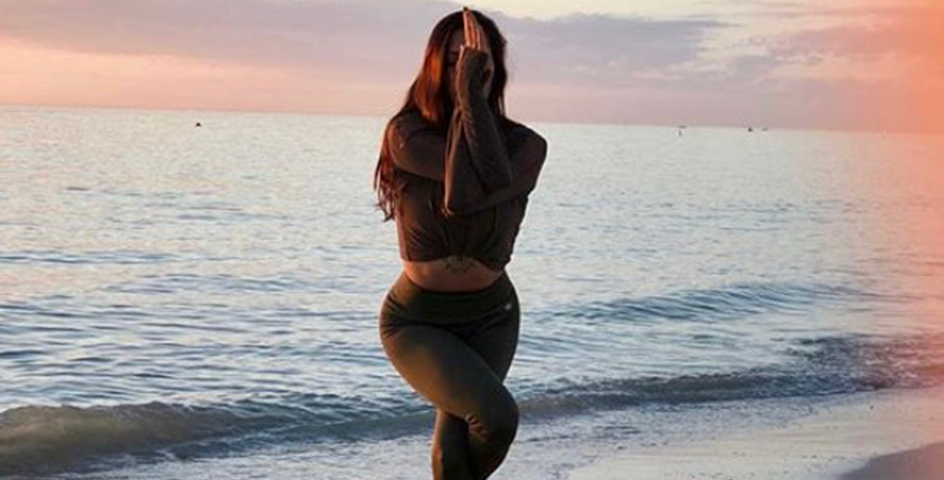 Woman in yoga pose on the beach