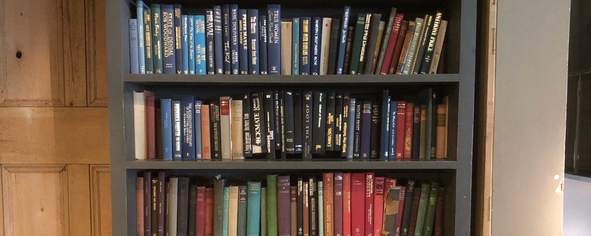 A lovely, tall bookcase with inviting, hardback books.