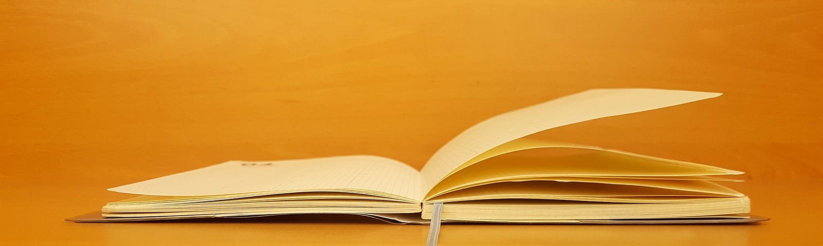 Open journal with golden amber background. Garden of Neuro Submission Guidelines — Write with us!