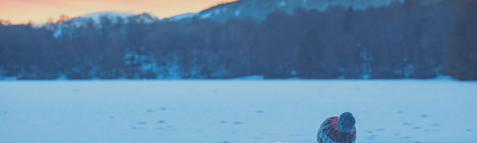 Person sitting in a frozen lake — perhaps doing the Wim Hoff breathing method to stay warm.