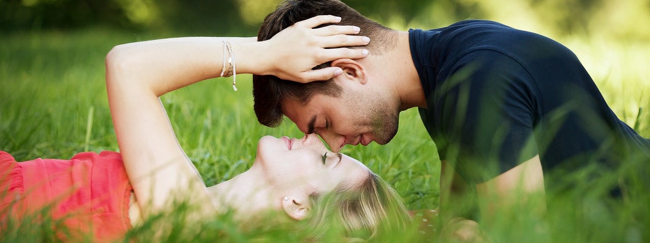 Couple in a field being intimate