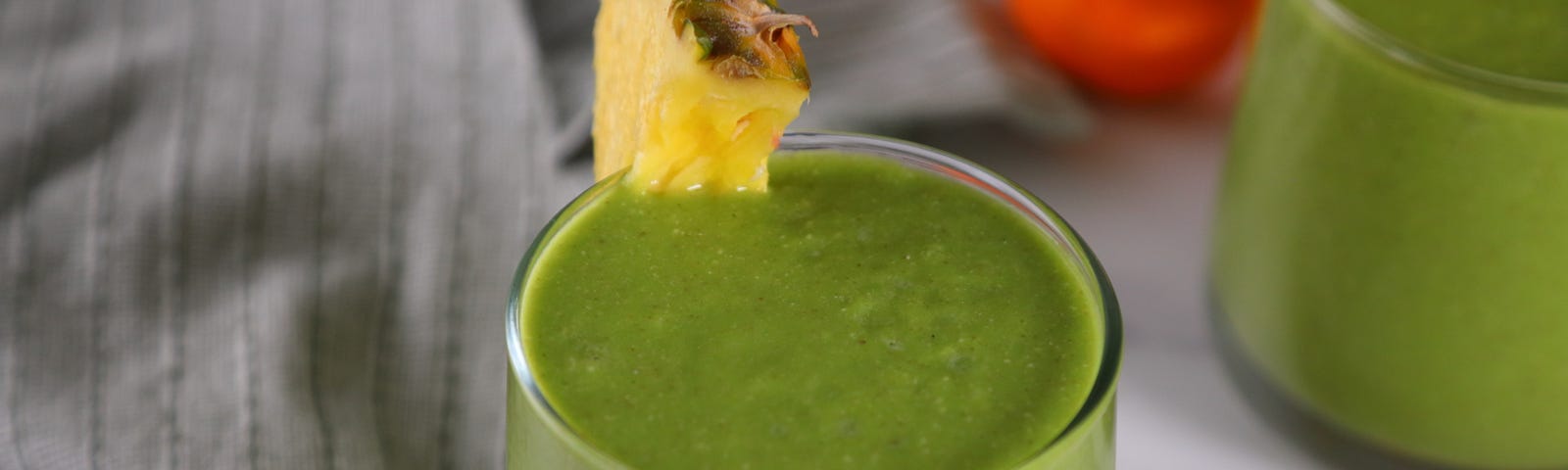 Tropical green smoothie in a glass with pineapple