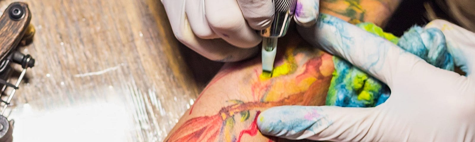 A person tattooing someone’s arm.