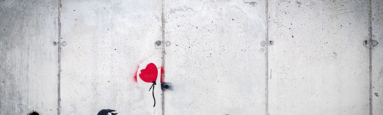 A stamp of a girl releasing a red heart balloon on a paneled wall