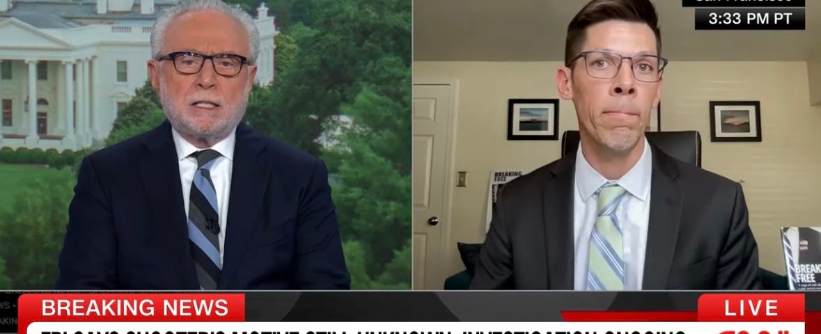 CNN interview. Cory Allen, Former Secret Service agent for Pres. Obama, is speaking above the headline: FBI says shooter’s motive still unknown, investigation ongoing. Allen wears a dark gray suit jacket, a collared shirt, and a pale green tie with blue stripes.