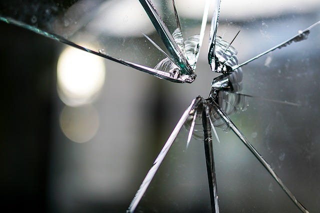 cracked window pane made of glass in front of a blurred background