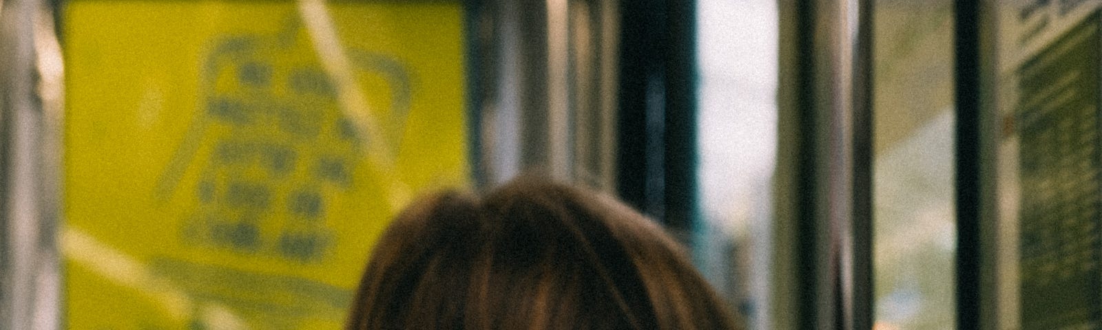 The back of the head of a brunette woman sitting on a bus. Photo by Mathias Reding: https://www.pexels.com/photo/back-of-the-head-of-a-woman-sitting-in-a-bus-9845230/