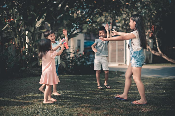 Kid playing outside having fun with bubbles.