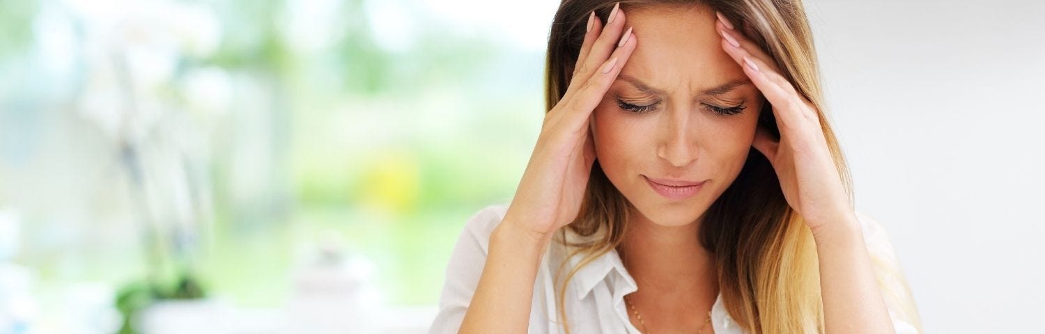 Woman with head in her hands for an article about cheating and emotions