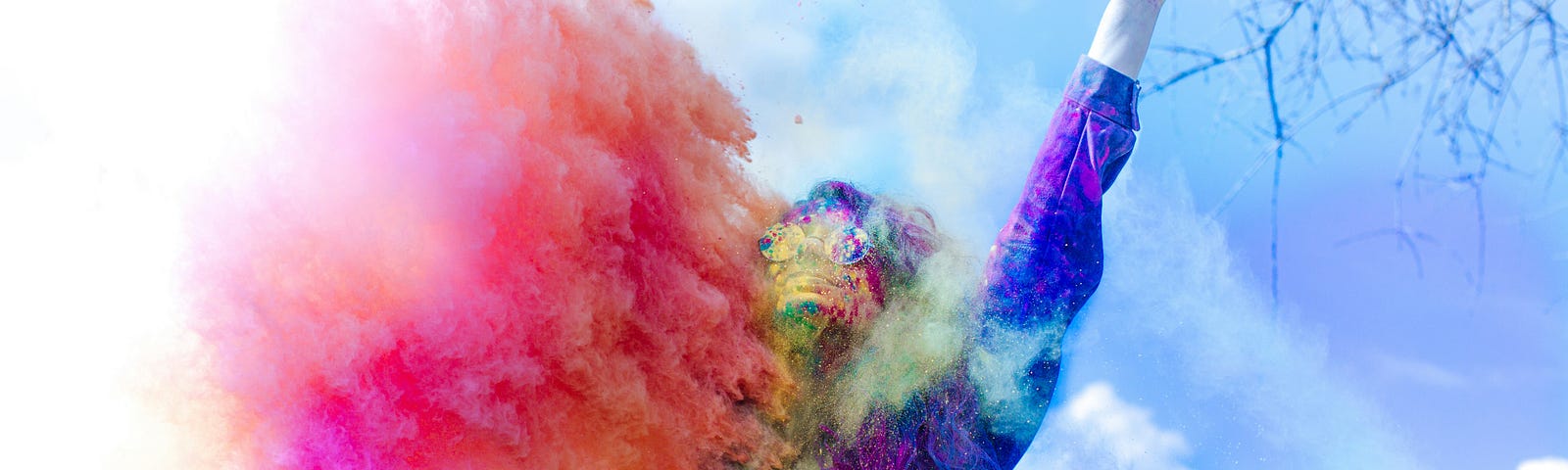 A person throwing multi-coloured powder paint.