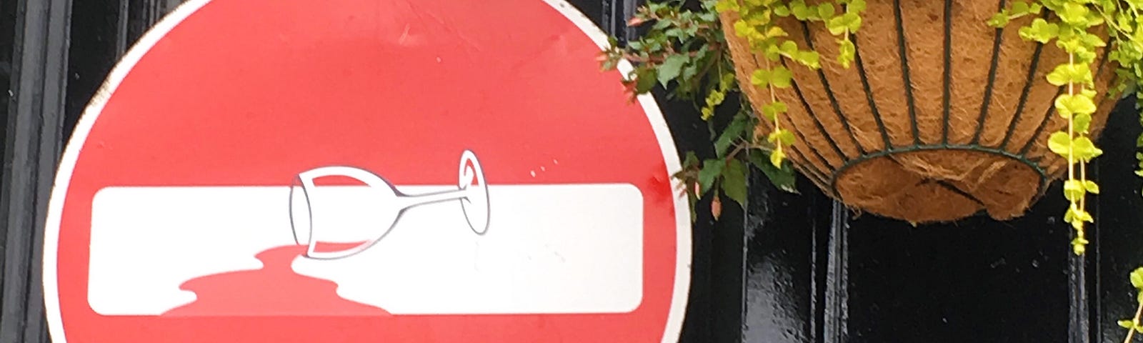 No Entry sign with an empty wine glass superimposed to look as if the red circle of the sign is spilled red wine.