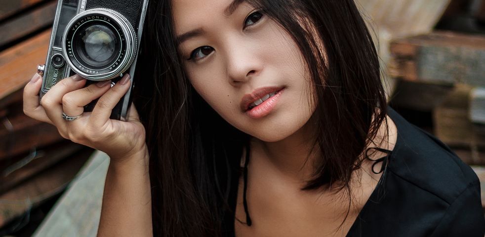 Woman in black dress holding a camera