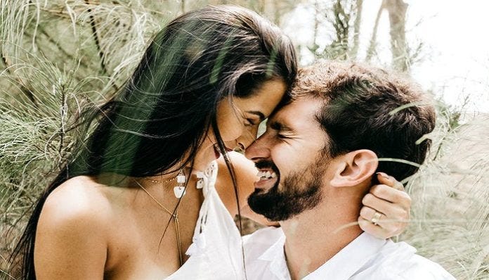 Photo of a young couple laughing and touching noses