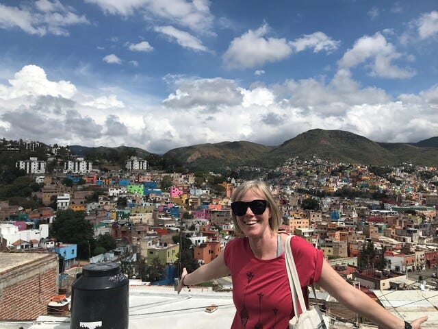 The author standing in front of a view of a Mexican city.