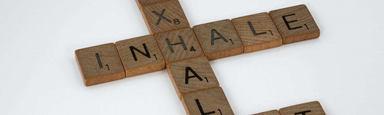 Scrabble tiles spelling out Inhale, Exhale, Repeat