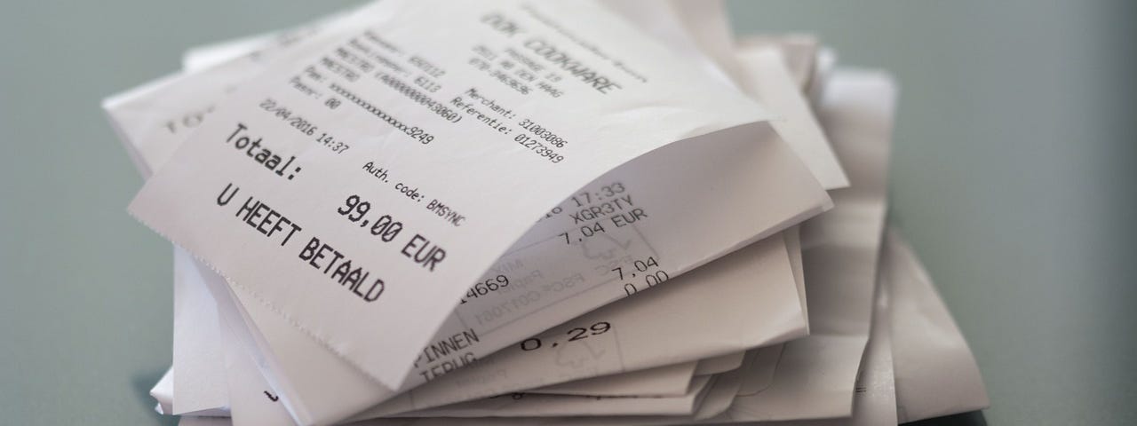 IMAGE: A bunch of shopping receipts piled on a table