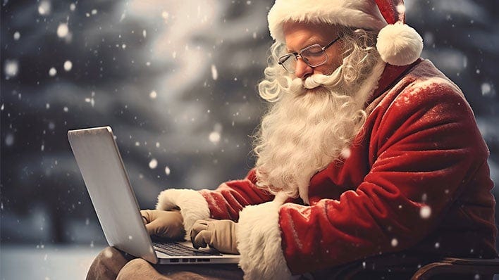 Santa Claus typing on a laptop while outside