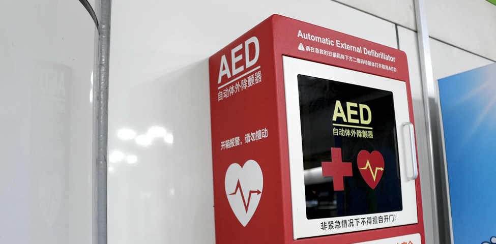 An AED in a red box mounted on a wall