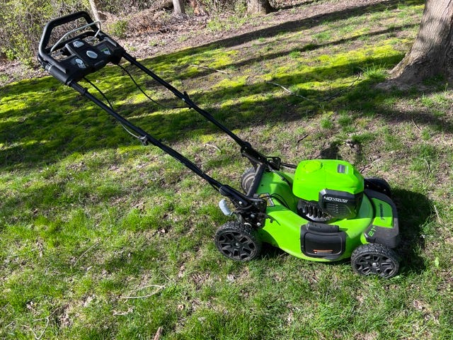 One of Greenworks 40V Self Propelled lawnmowers sitting on a freshly cut lawn.