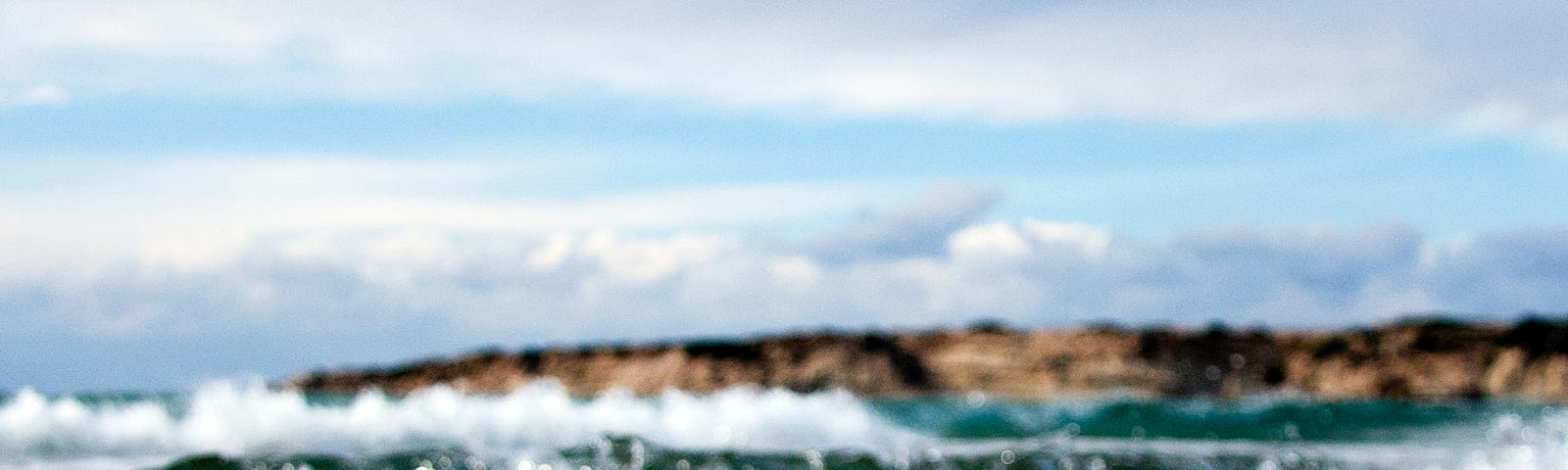 Image at ground level of the ocean coming onto the shore