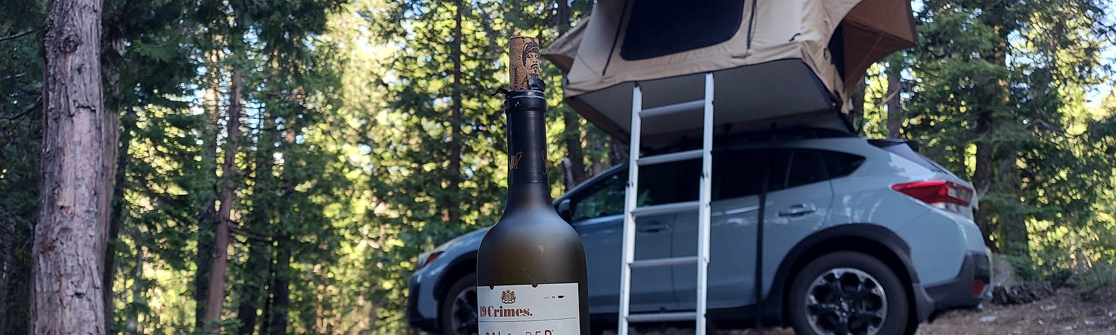 Our rooftop tent with a bottle of Snoop’s red wine sitting on a table in front.