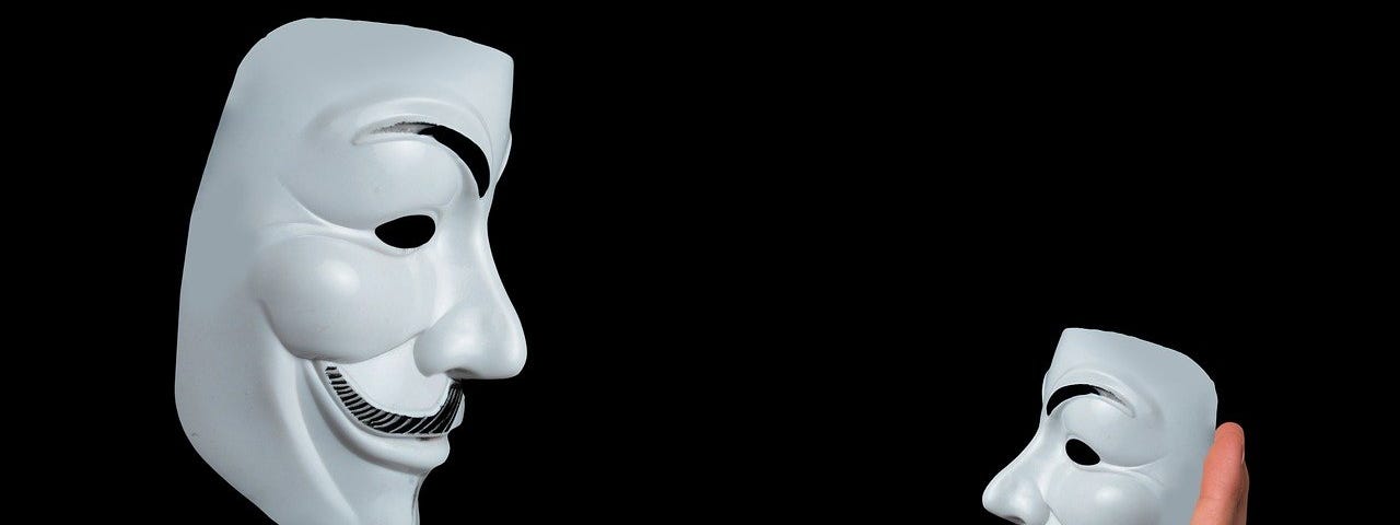 large white theater mask holding a smaller mask at arm’s length indicating critical thinking