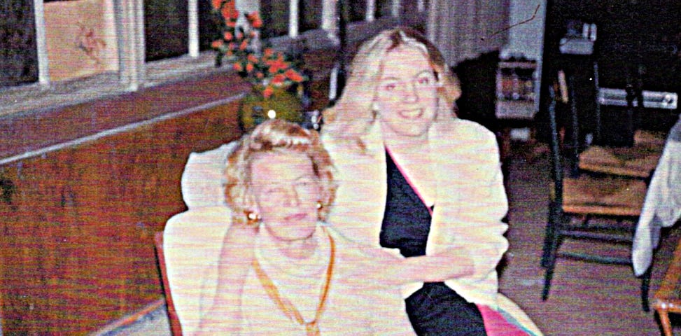 A middle-aged woman and a young woman sit close together.