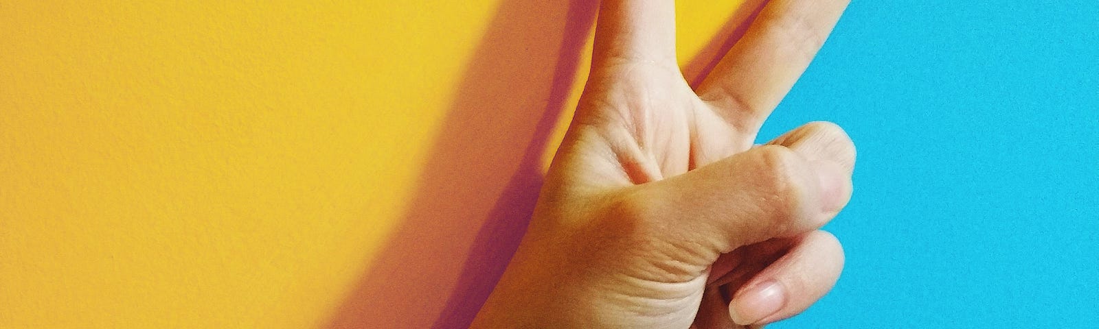 two fingers raised against a blue and yellow background