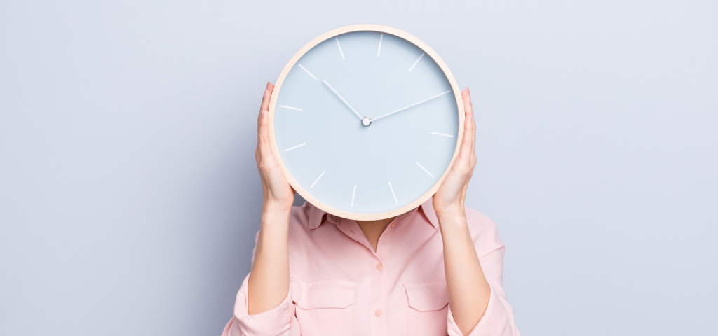 Time Management: A women holding a clock in front of her face