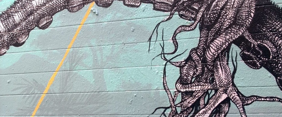 An up-close snap of the tentacles of Alexis Diaz’s beautifully detailed hybrid Elephant Octopus painted in black and white on a pale turquoise brick wall. One of the tentacles has snapped to reveal the sinew inside.