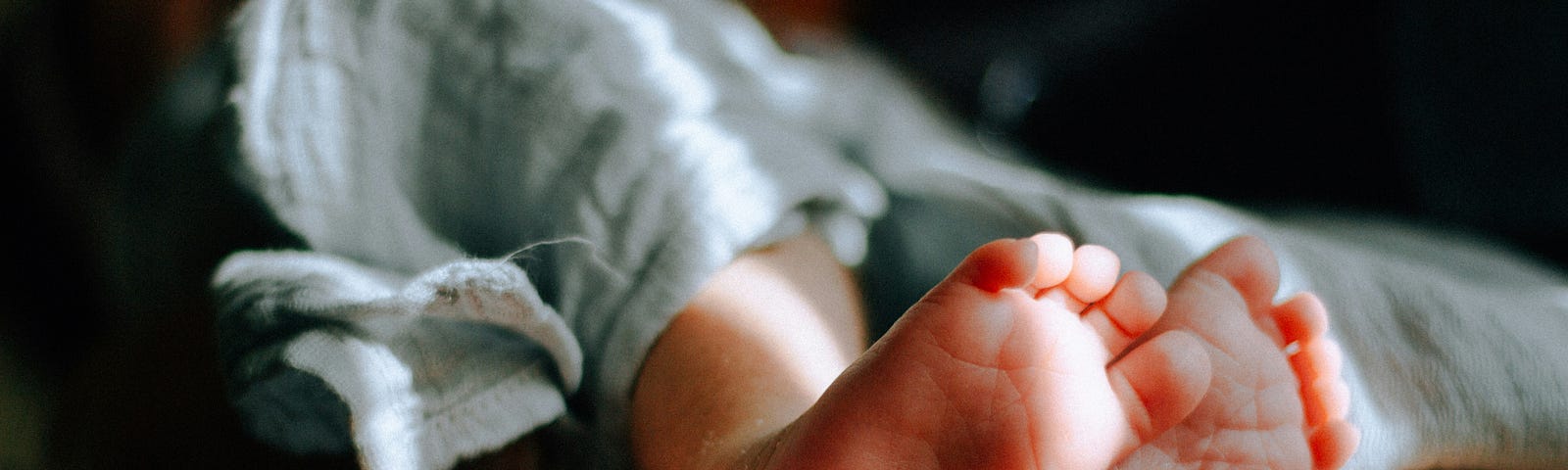 A newborn baby’s feet cradled in a mother’s hand.