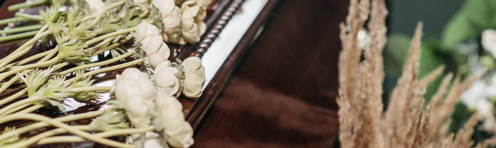 white flowers on wooden coffin