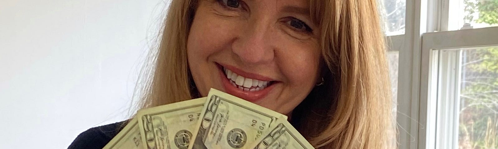 Pretty woman smiling holding money from savings