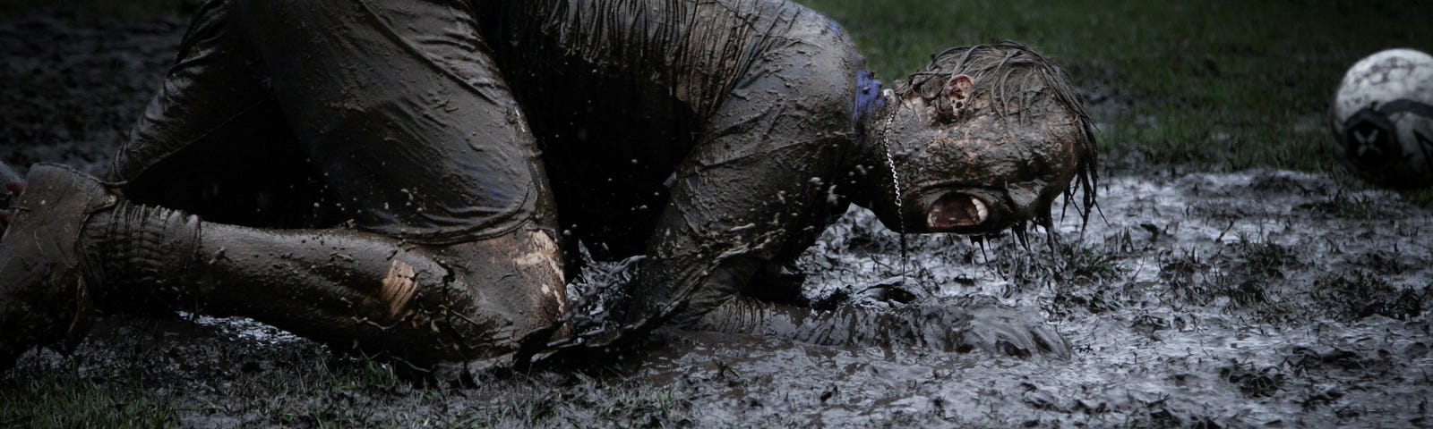 man lying in a pool of mud