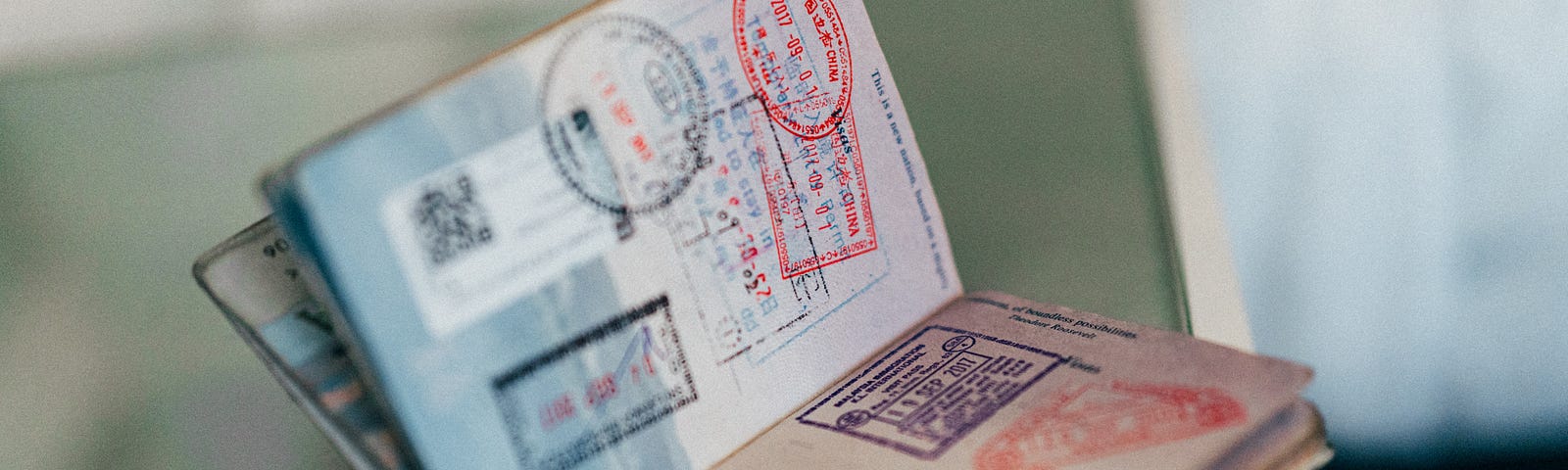 An image of a stamped Passport on a blurred table.