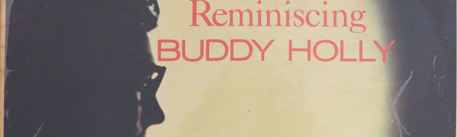 Image of the 1963 Album cover of Coral recording ‘Reminiscing’ by Buddy Holly, with photo of Buddy Holly seated in a airplane near the window
