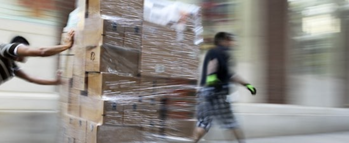 Workers moving boxes in warehouse.