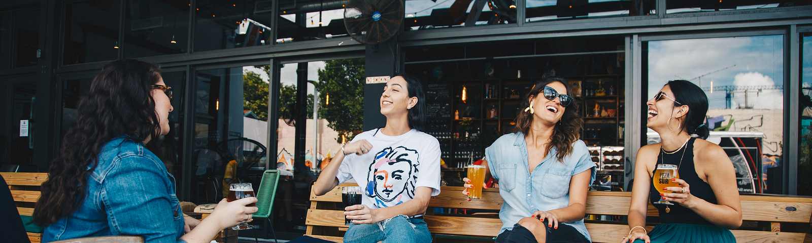 a group of friends sitting around a table drinking beer