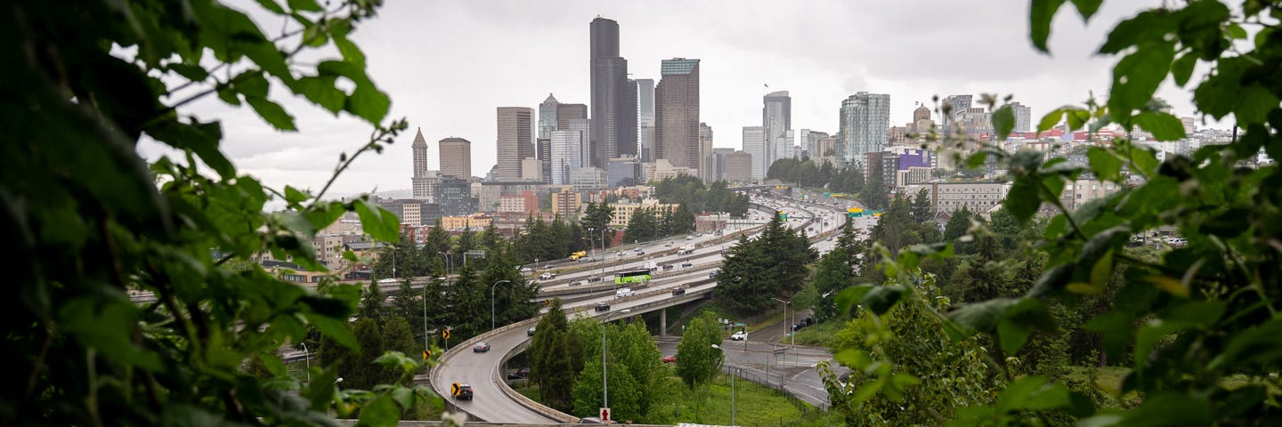 The Seattle skyline on a cloudy day with highways in the foreground.
