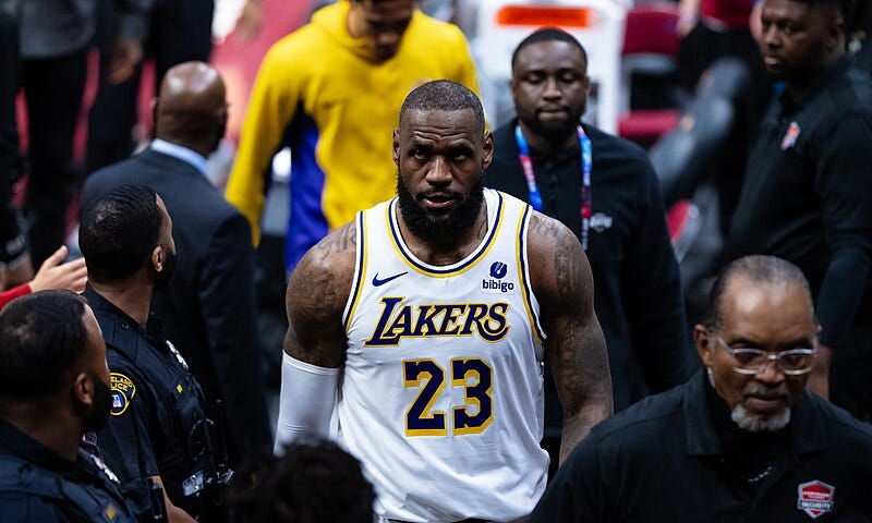 LeBron James heads down a tunnel surrounded by security and police officers after the conclusion of a Lakers game.