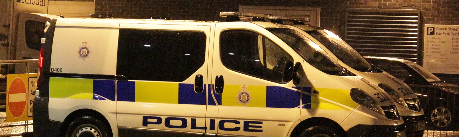 British Police van in rain parked up in nighttime under street lighting