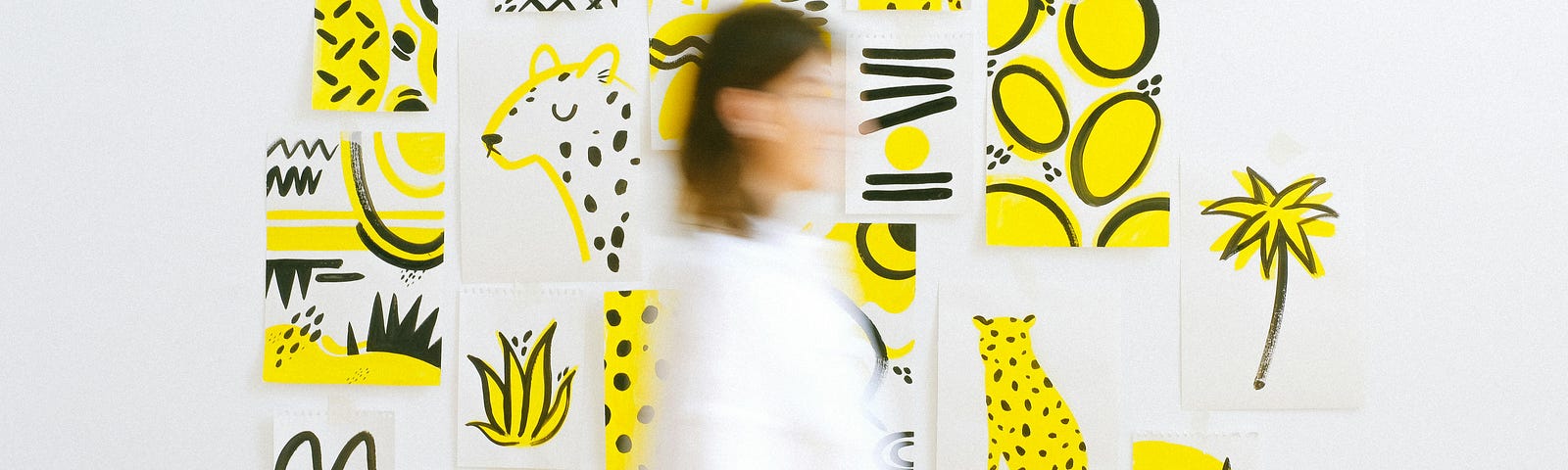 Woman Walking Against Wall With Several Art Sketches