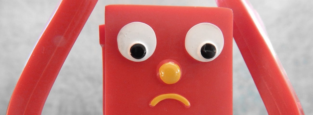 Image: A toy doll with an anxious frown.