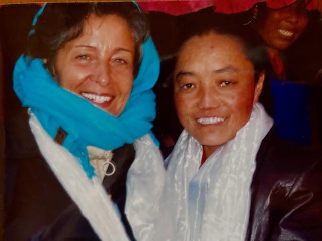 A nun standing with the author outside a rural monastery in Tibet. Both heavily clothed due to high altitude cold.