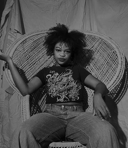 Charmaine Ejelonu sits in a wicker chair in a black-and-white image