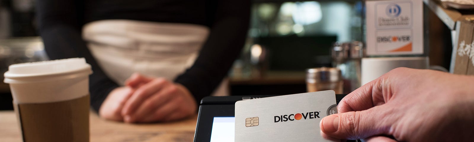 A customer makes a contactless transaction with a Discover credit card.