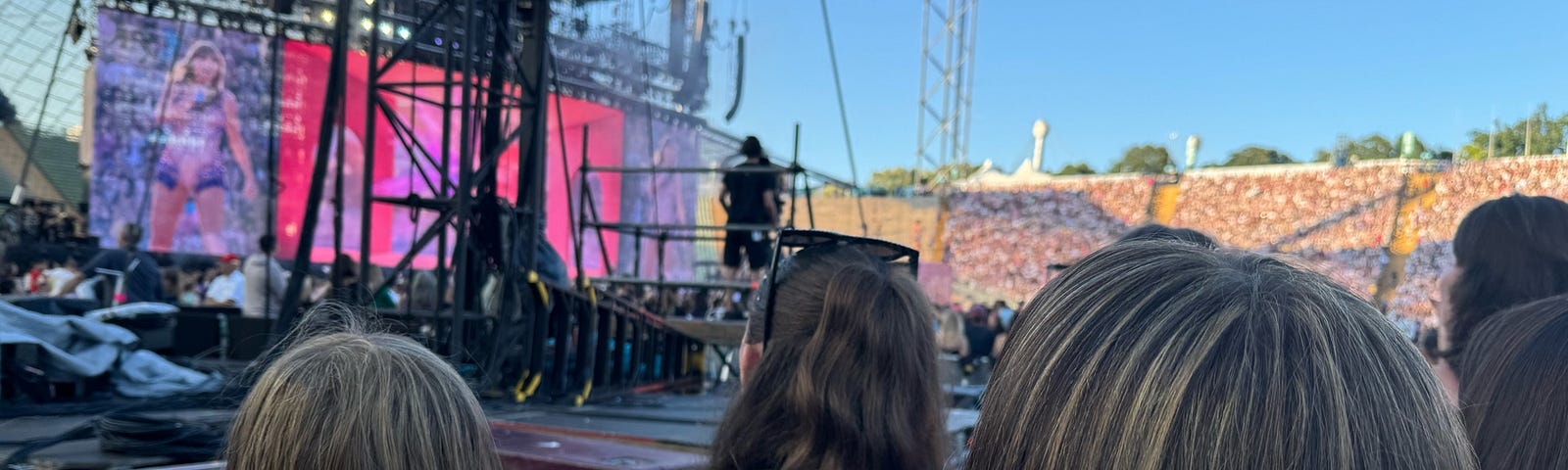 The back of two heads, watching Taylor Swift perform