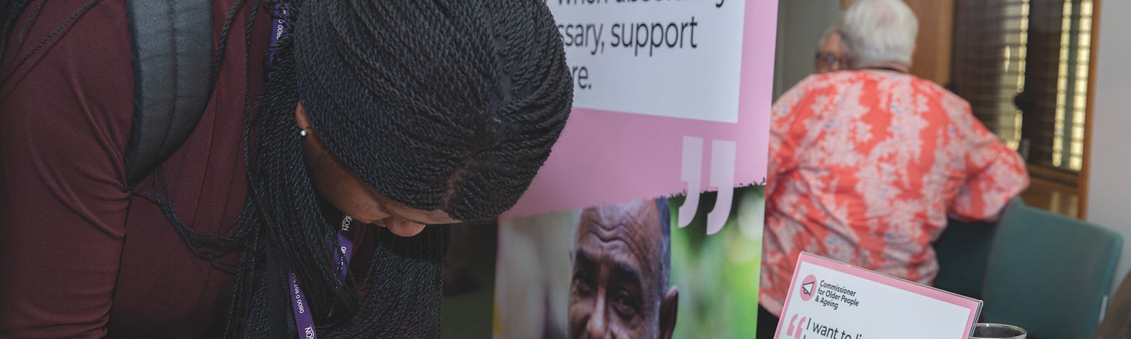 Woman writing on post it note at a stall as part of a campaigns event