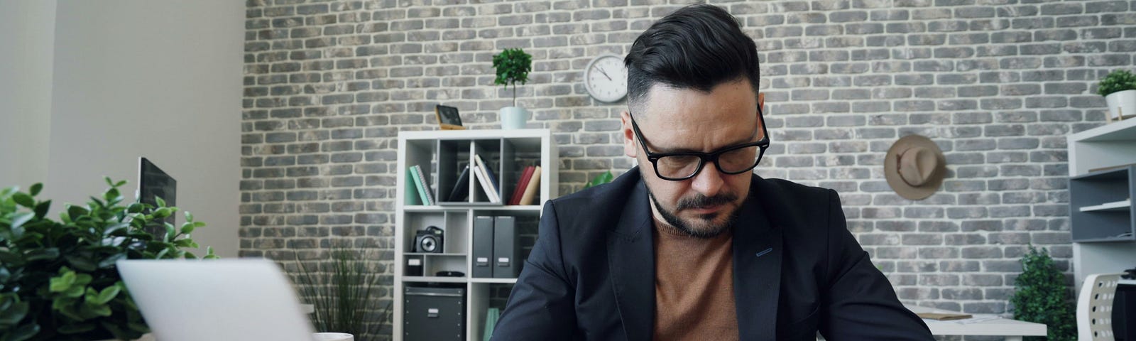 A guy counting money at his desk.